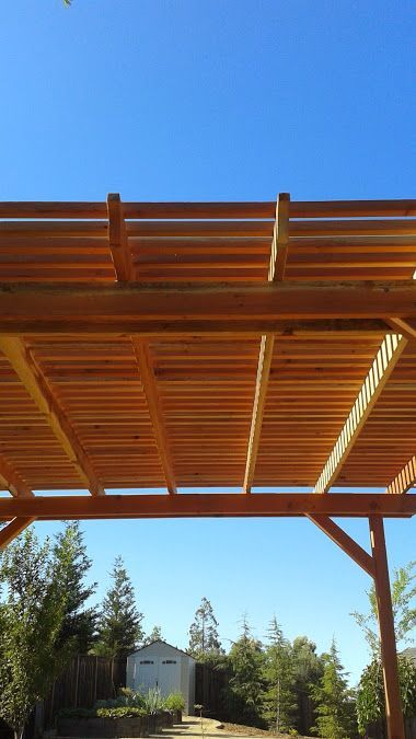 A wooden pergola with a blue sky in the background.