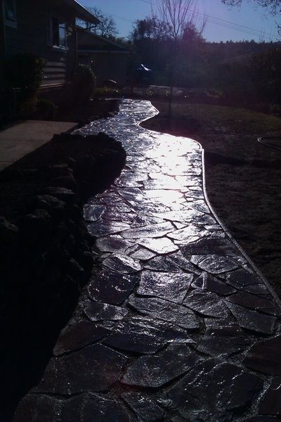 A stone walkway leading to a house on a sunny day