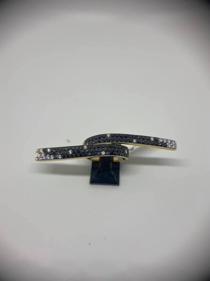 Sleek black-and-silver jeweled barrette on a small stand against a light gray background
