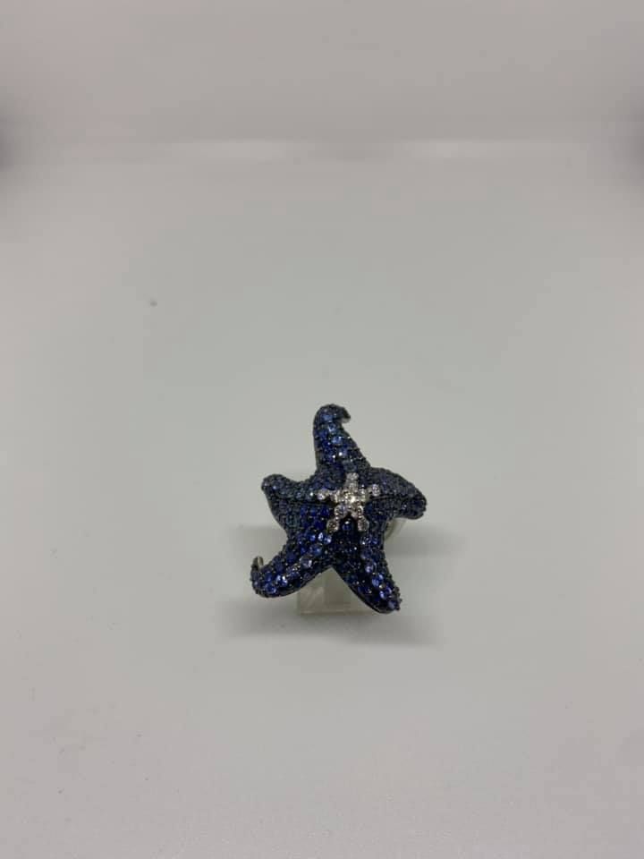Small dark blue starfish figurine with a textured surface on a plain light background