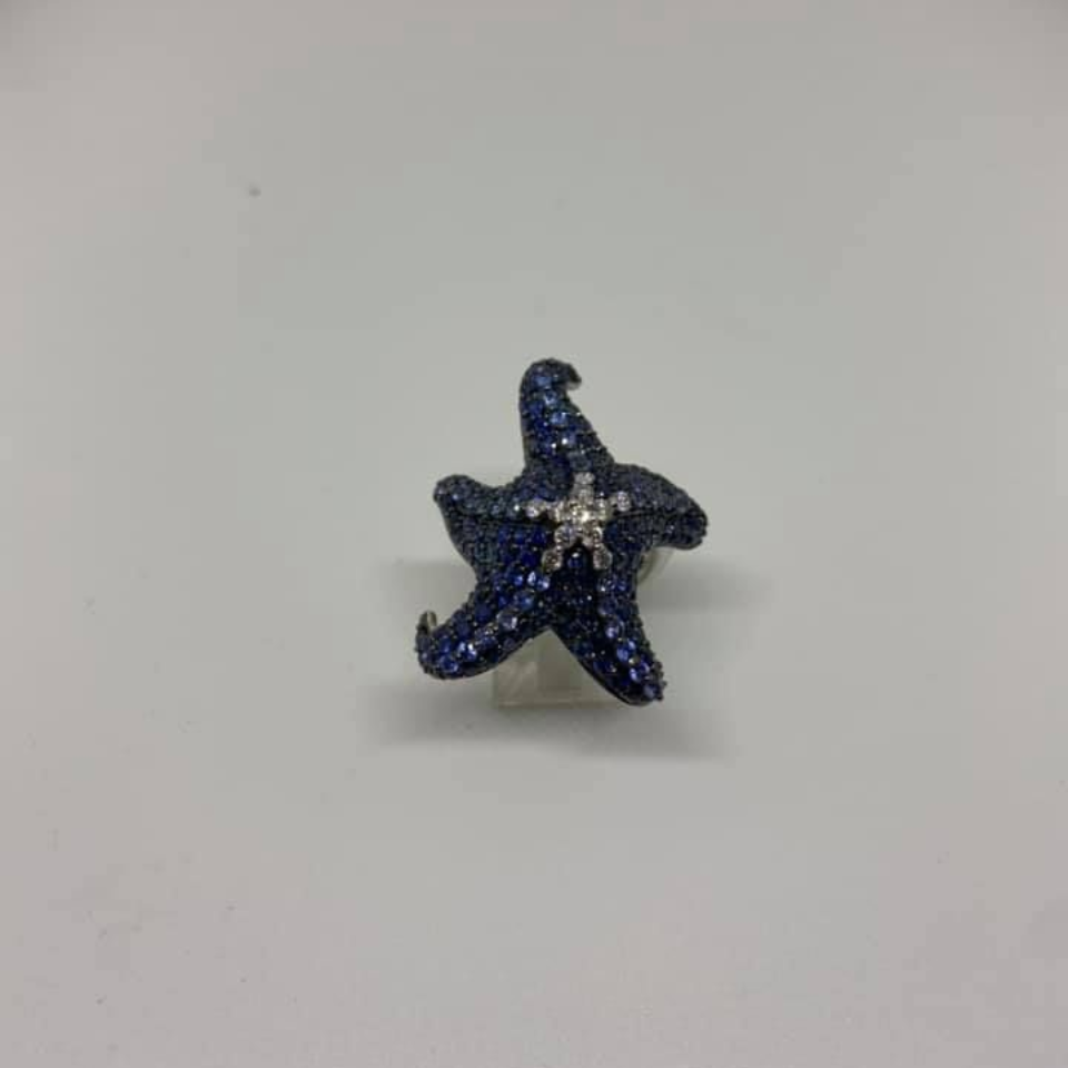 Blue star-shaped glittery pendant on a plain light background