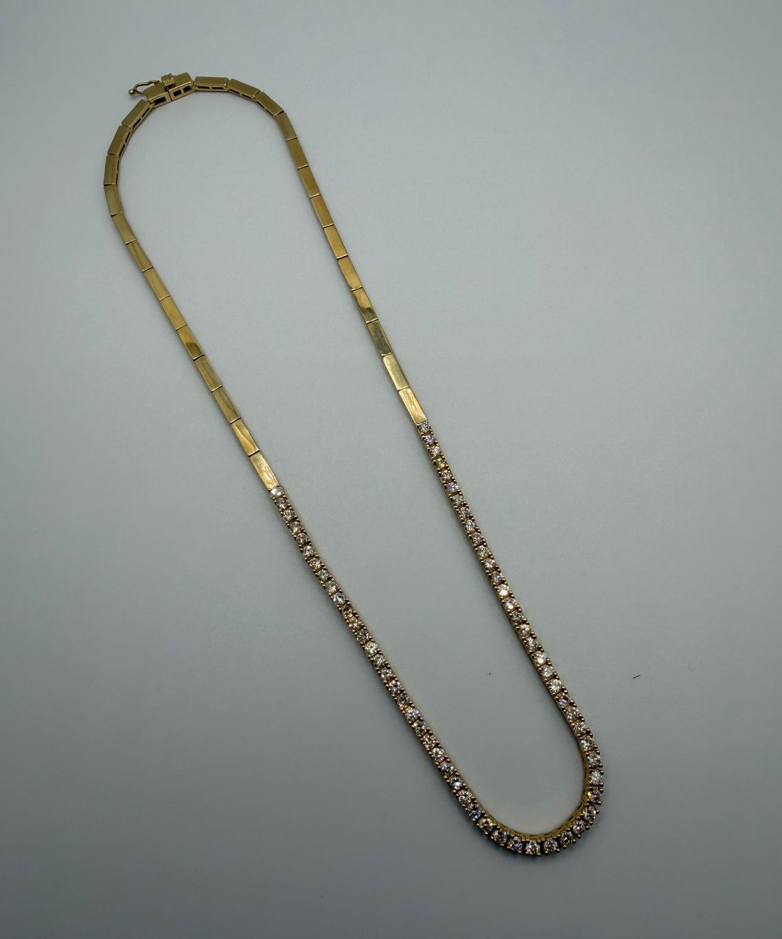 Gold chain necklace on a light gray background