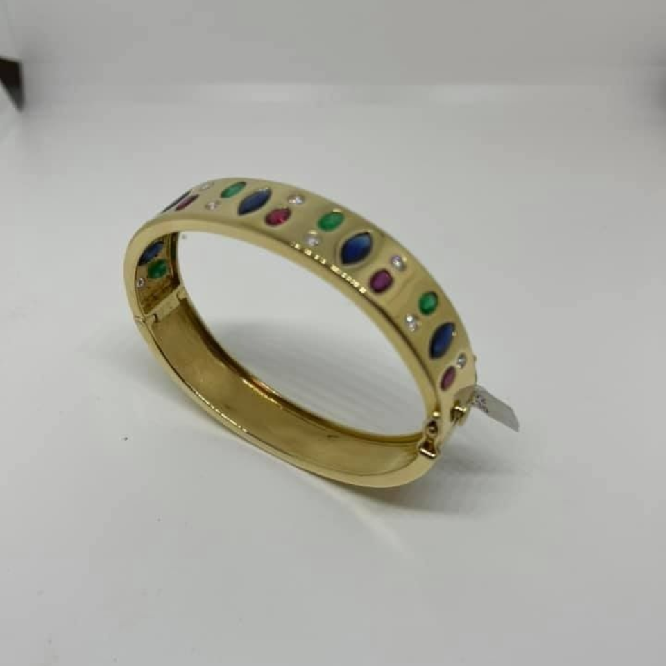 Gold bracelet with multicolored gemstones on a white background