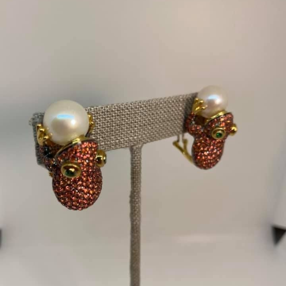 Pair of beaded strawberry-shaped earrings with pearl tops on a display stand