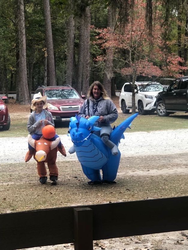 Two people in inflatable costumes, one a horse and one a dragon, outdoors.