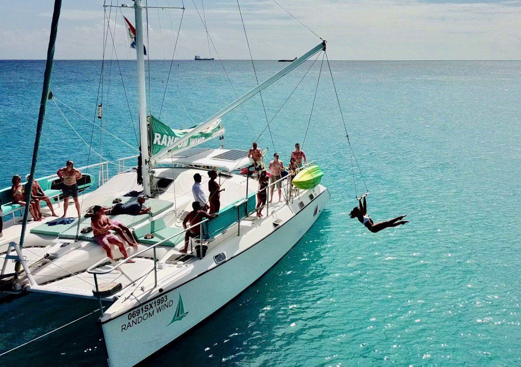 Woman swinging from Random Wind Yacht