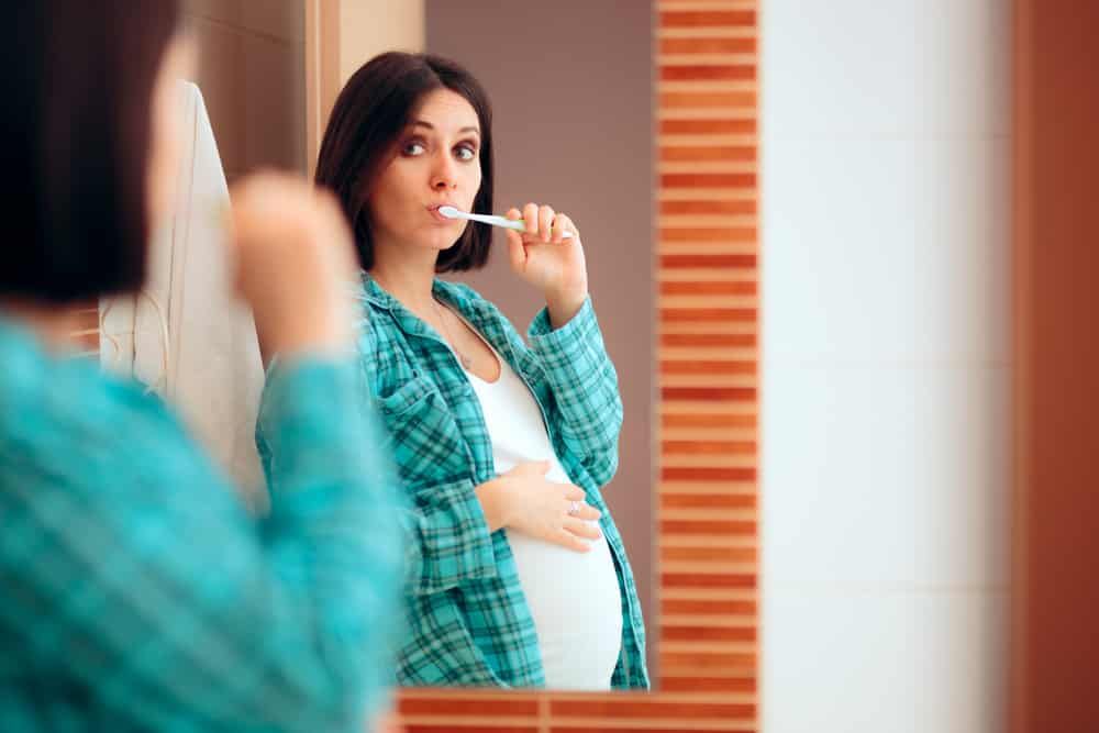 Pregnant lady brushing her teeth