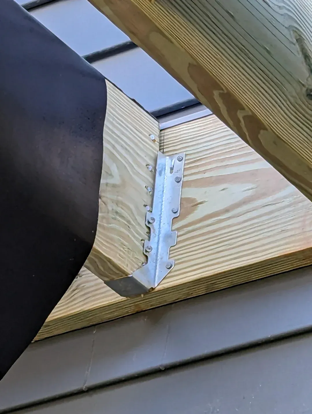 A close up of a piece of wood with a metal bracket attached to it.
