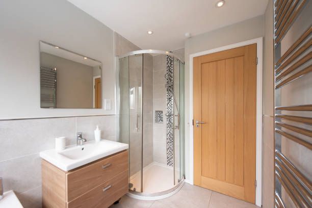 A bathroom with a sink , mirror , and walk in shower.