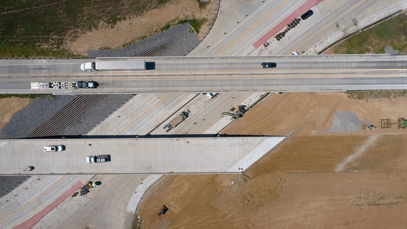 An aerial view of a highway with trucks driving on it.