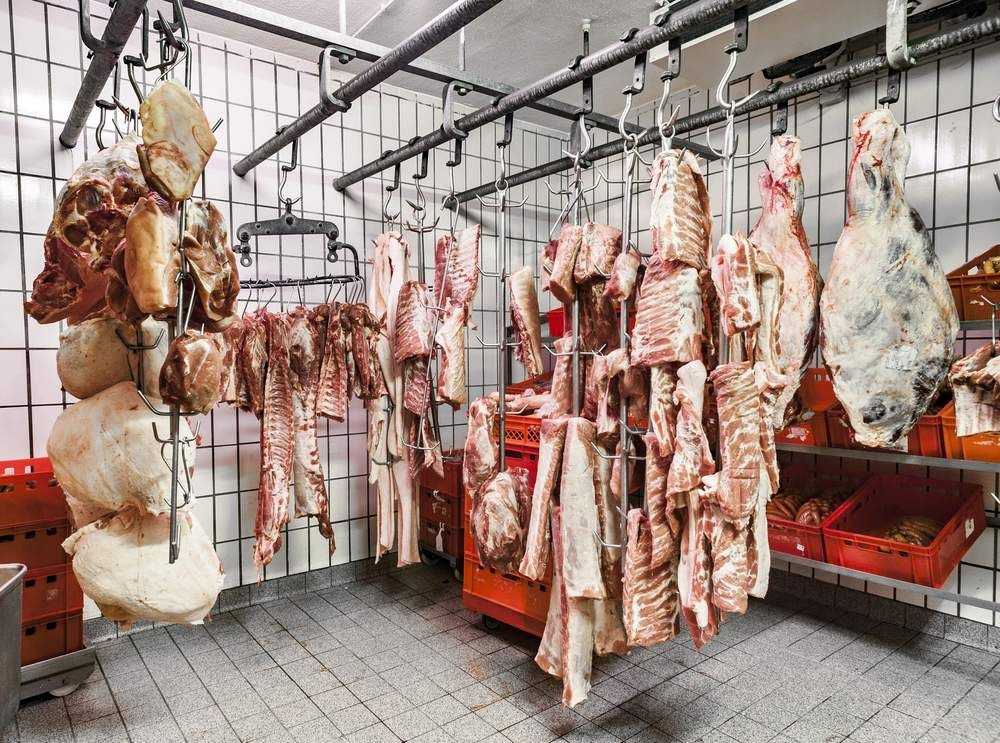 A Room Filled With Lots of Meat Hanging From Hooks — Complete Airconditioning & Refrigeration in Darwin, NT