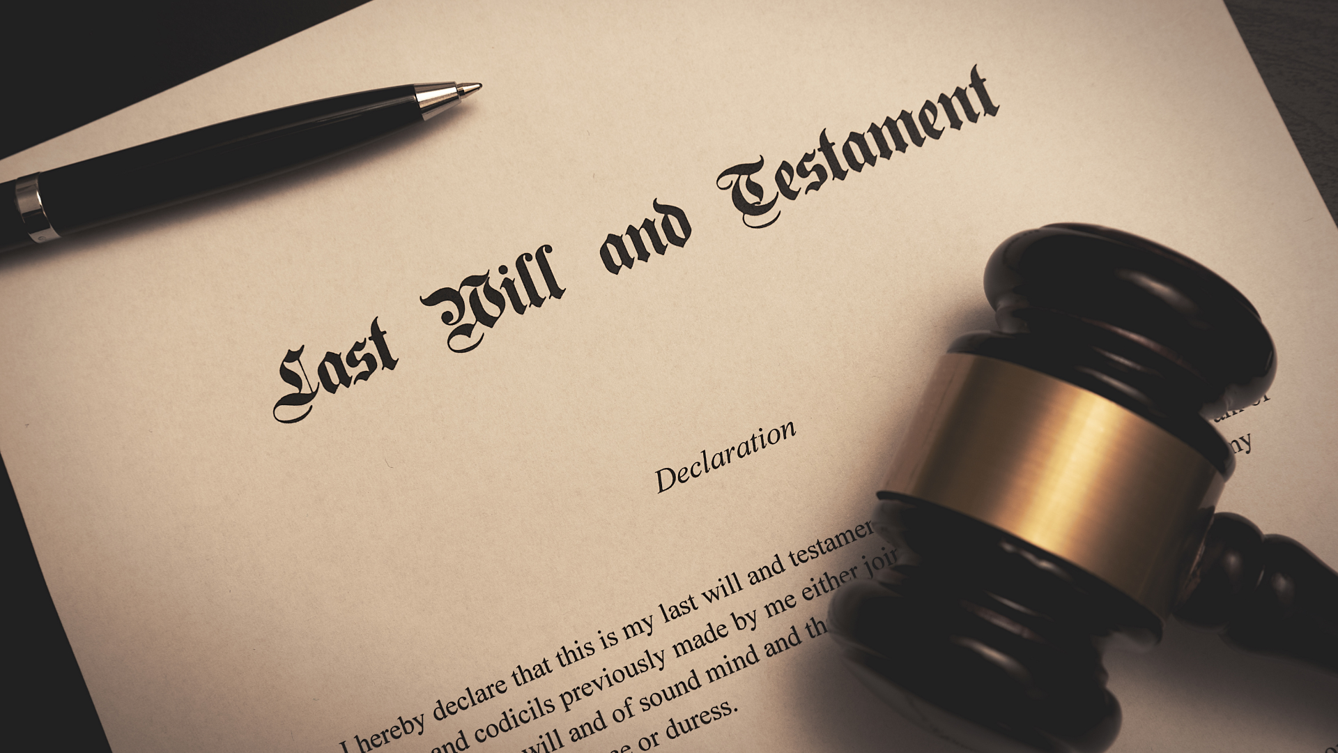 Last Will and Testament document with gavel and pen on a dark background.