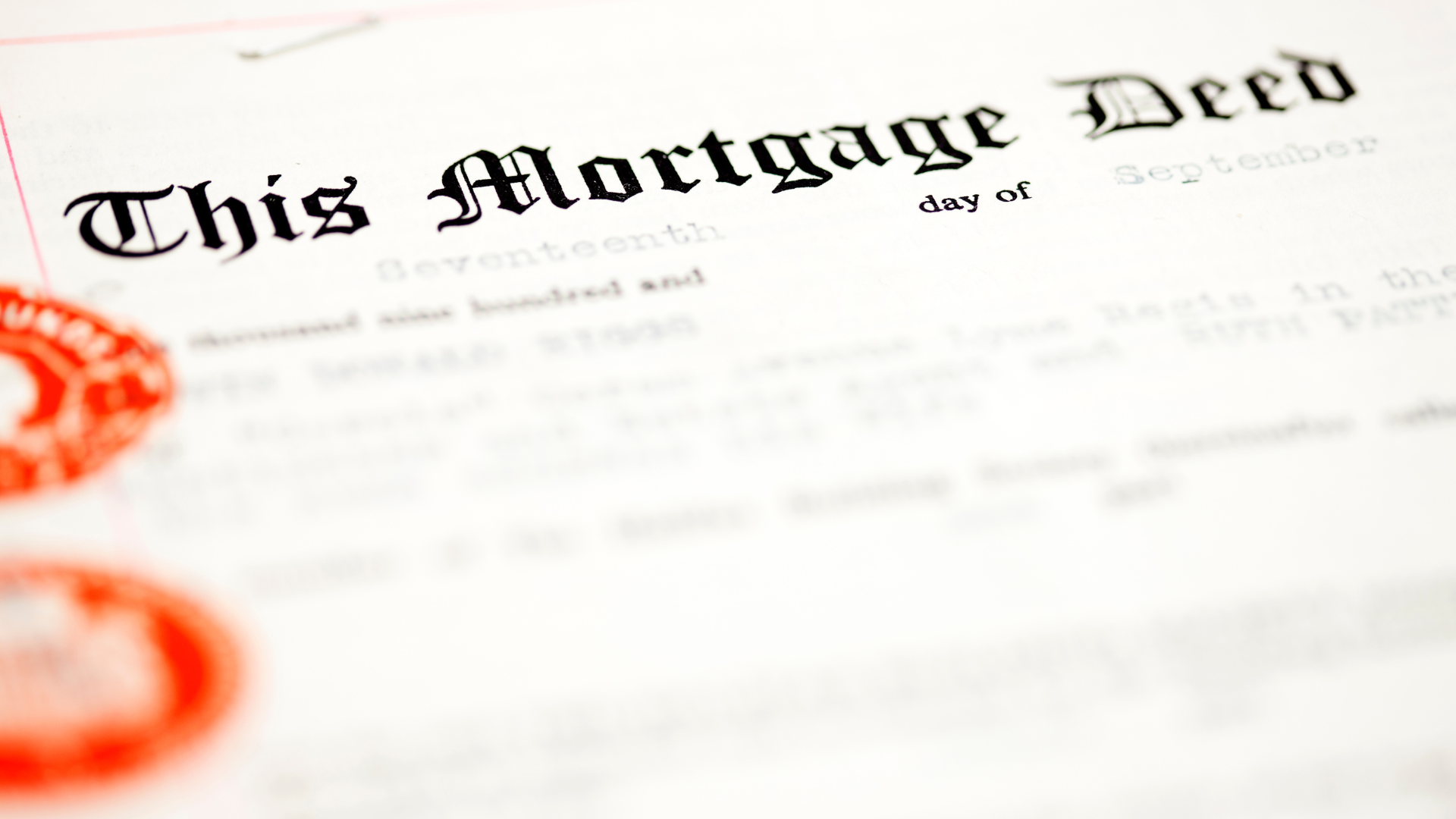 A close up of a mortgage deed with a red stamp on it.