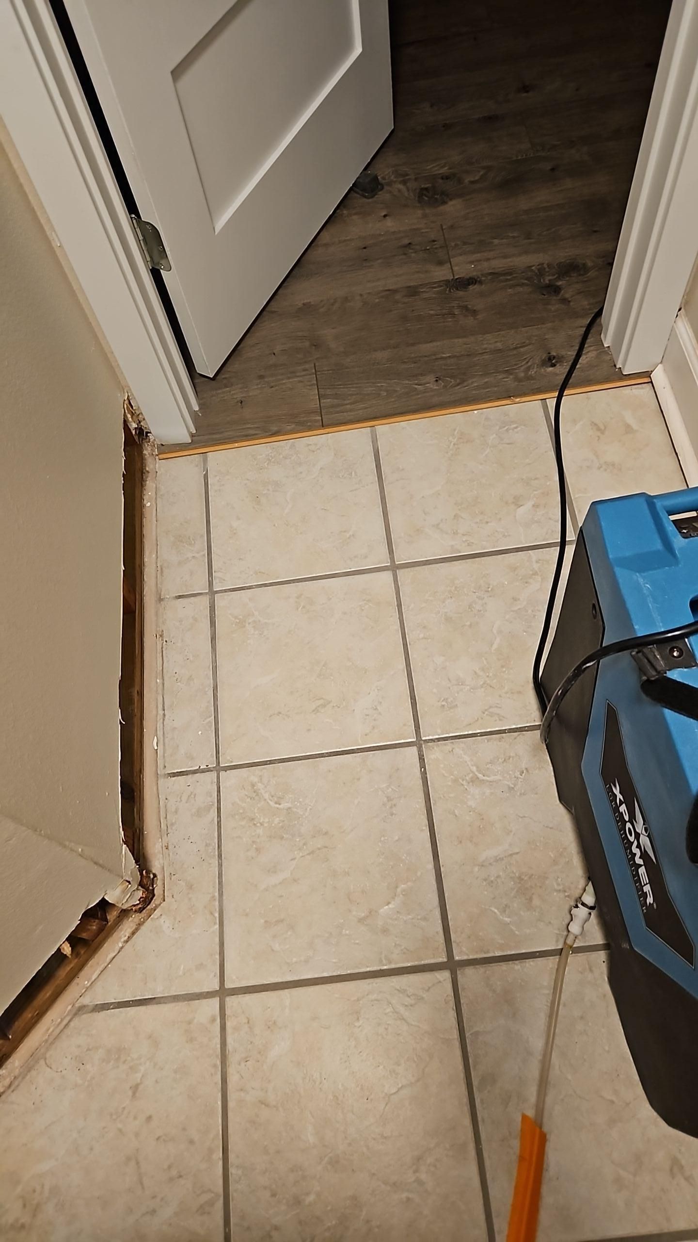 Detached baseboards and cut drywall during water damage demo work