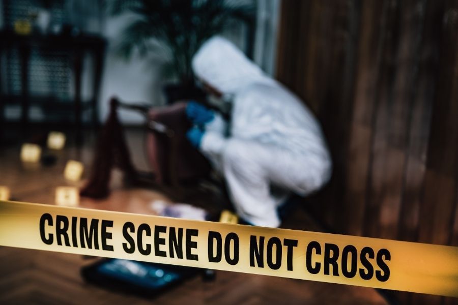Professional biohazard cleanup technician in protective gear at crime scene