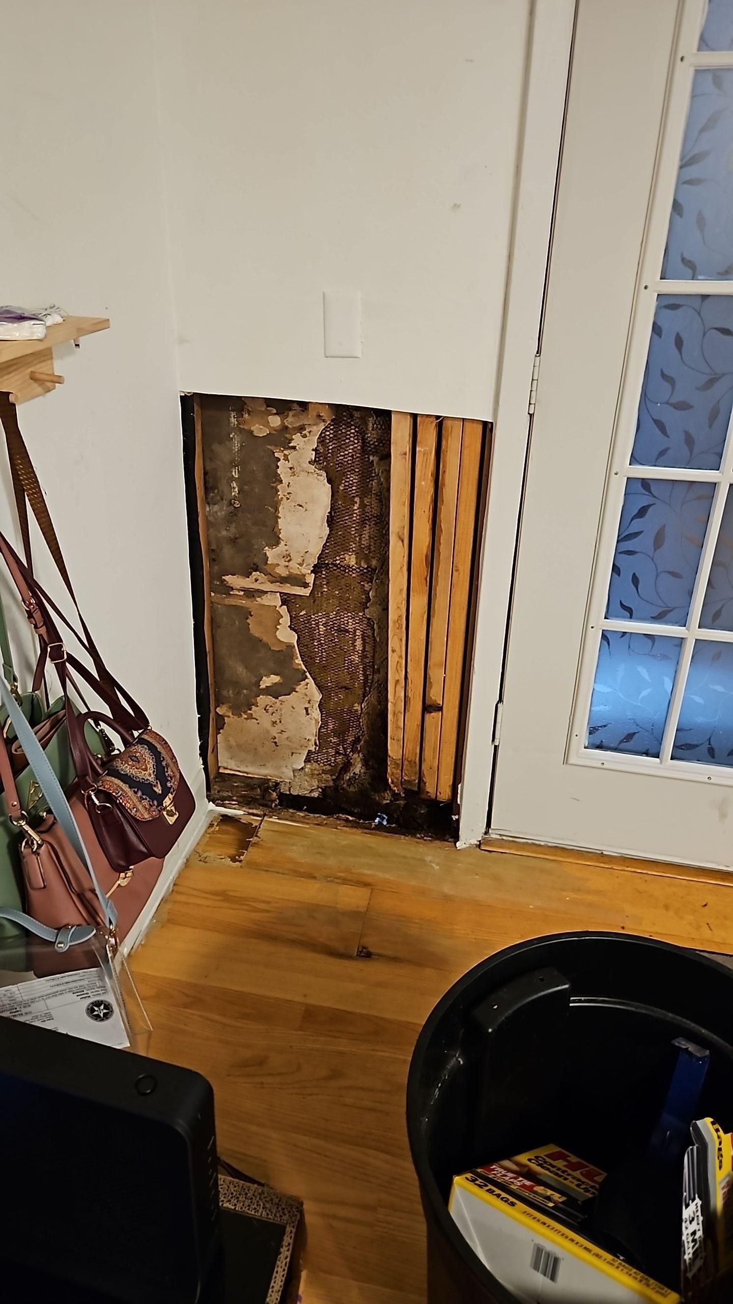 Drywall removal exposing wall cavity during water damage mitigation in Austin TX living room