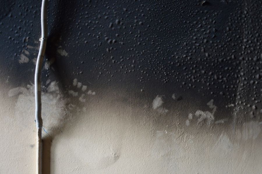 Drywall showing extensive soot penetration after house fire