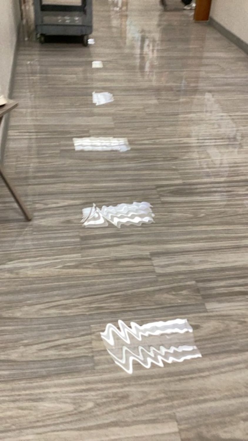 Flooded break room with water pooling around appliances and storage bins