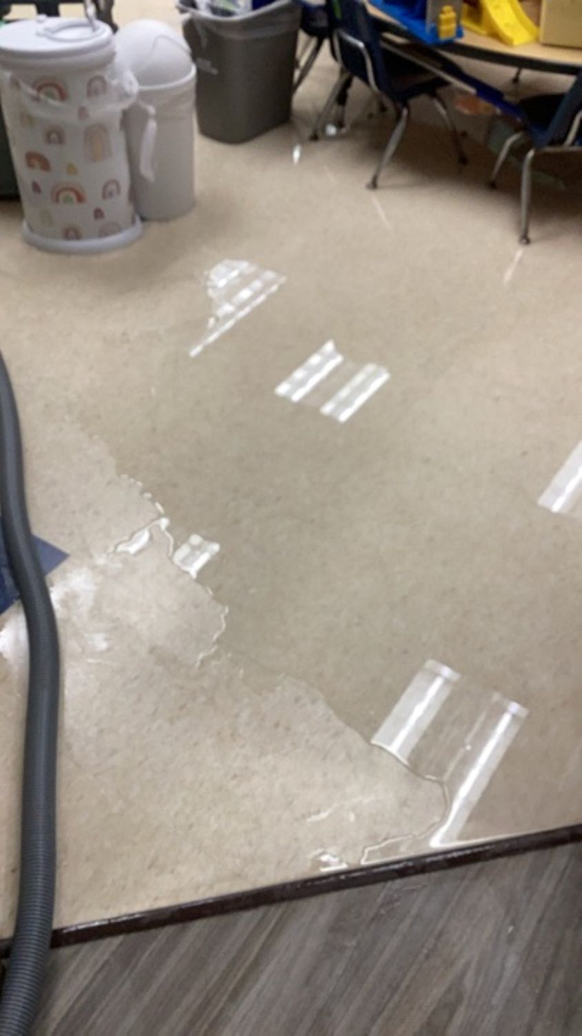 Water damage visible on church classroom floor with children's furniture