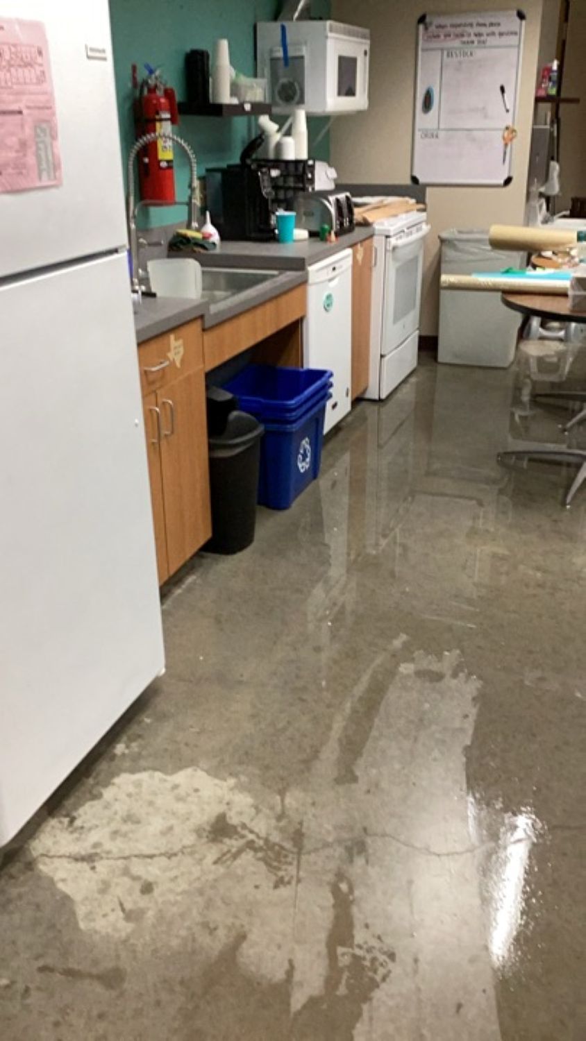 Flood damage in children's ministry classroom with play equipment and standing water