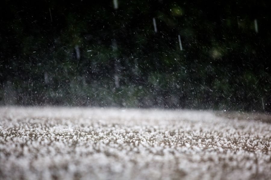 Hail storm damage on a Central Texas property with large hailstones on the ground