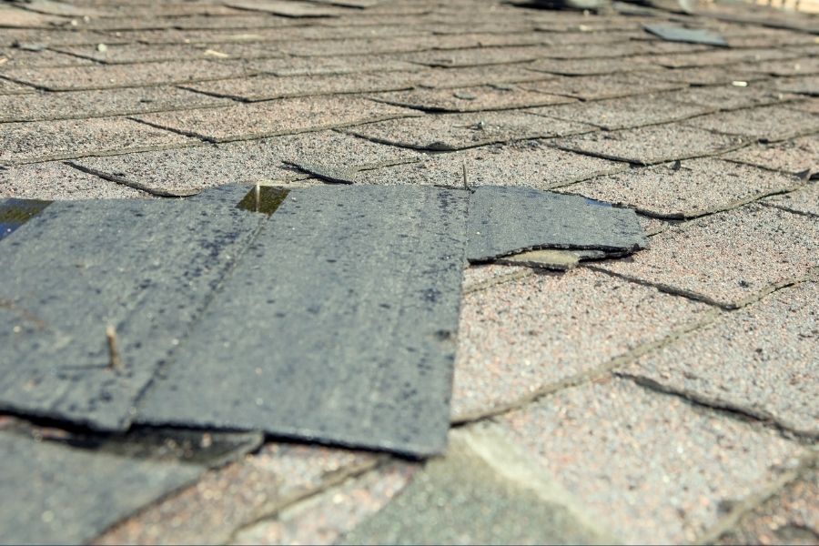 Inspecting a roof for missing shingles before hurricane season
