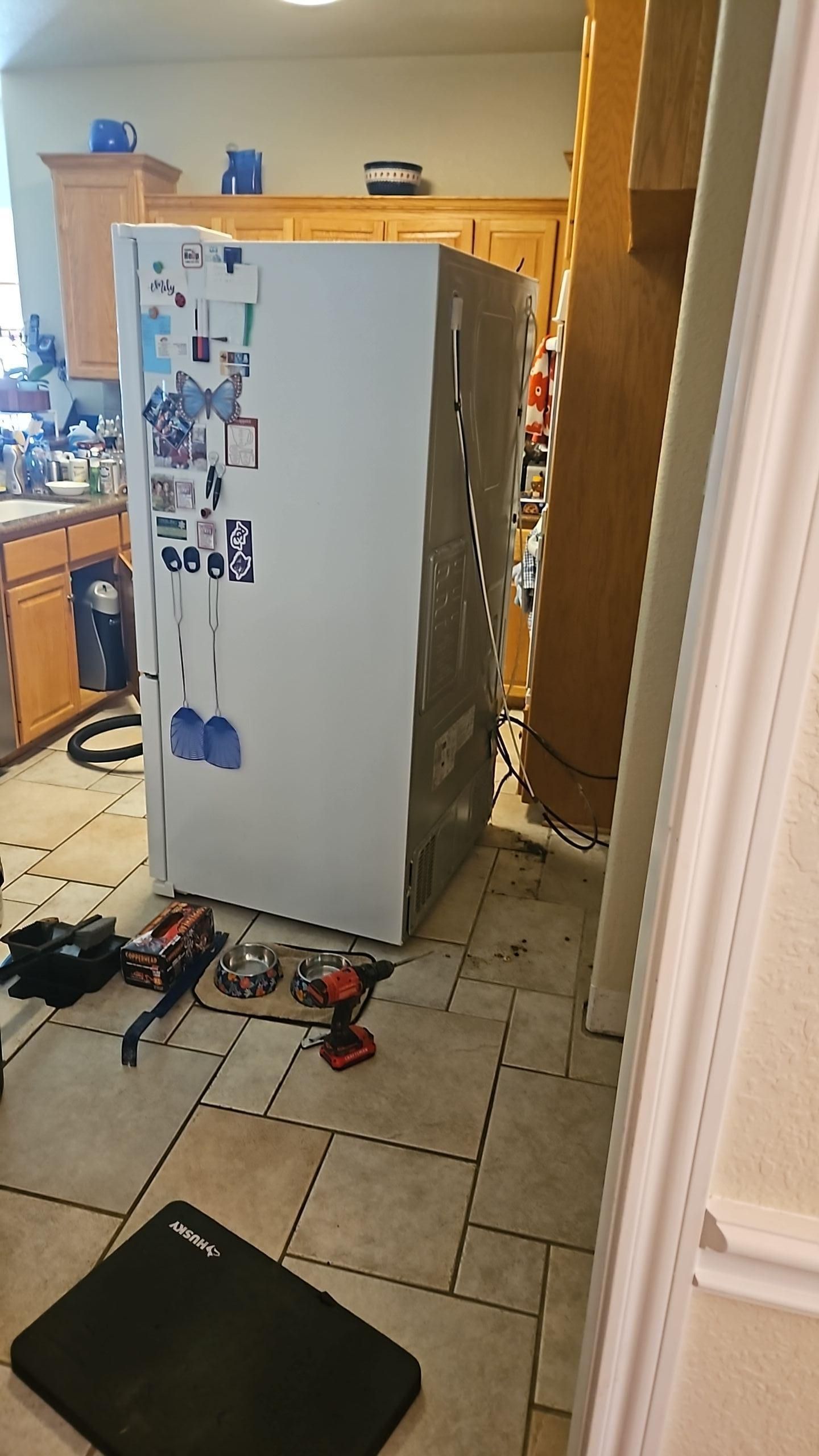 Kitchen water damage assessment showing moisture migration along base cabinets and floor