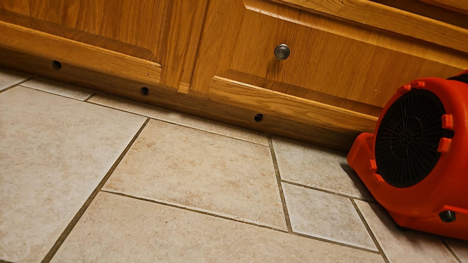 Drying equipment deployed in kitchen including air movers positioned along water-damaged walls