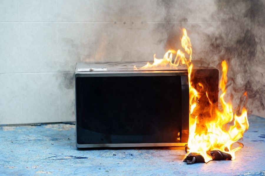 Minor fire damage from a microwave fire showing smoke and soot on kitchen walls