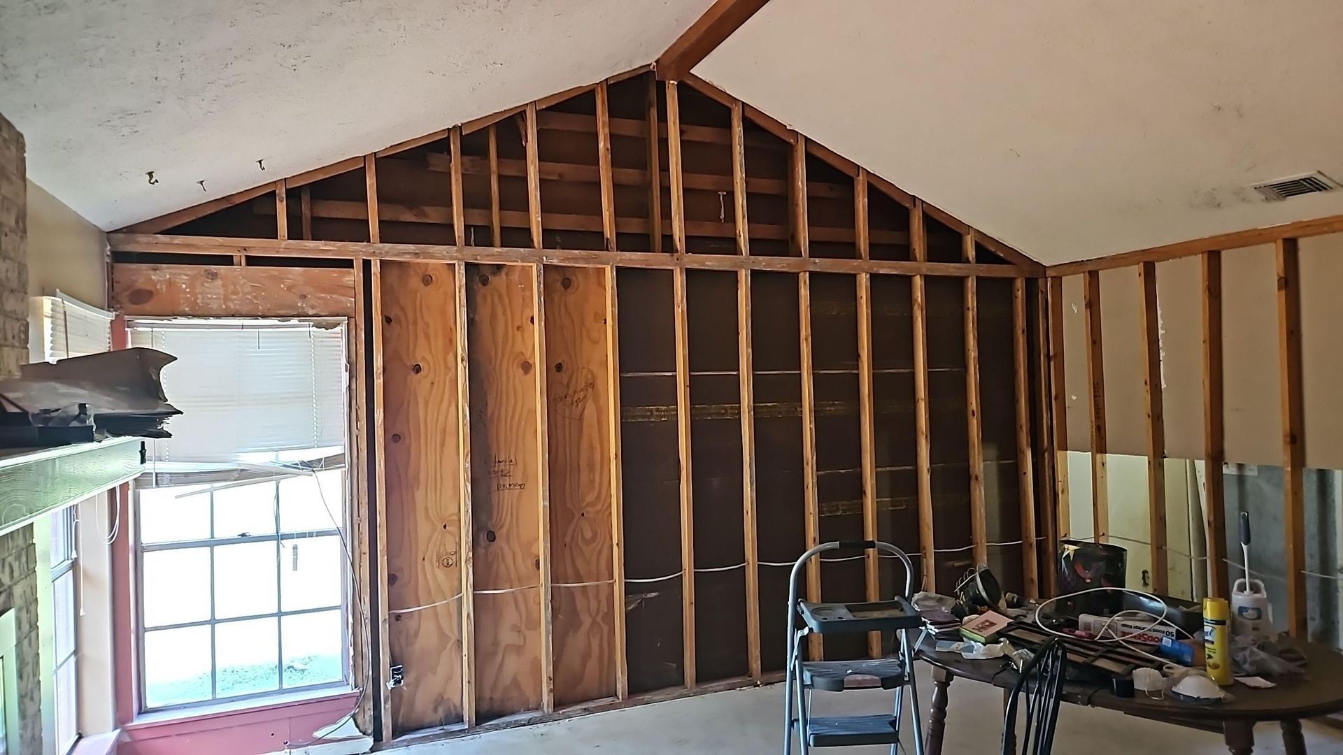 Cleared room interior after full drywall and insulation removal ready for antimicrobial treatment