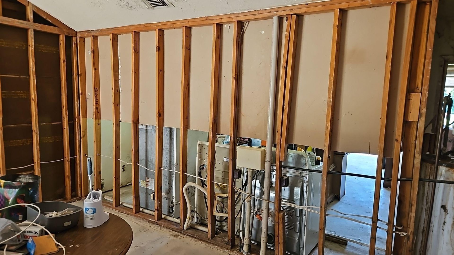 Antimicrobial spray applied to exposed wall framing after drywall removal during mold remediation