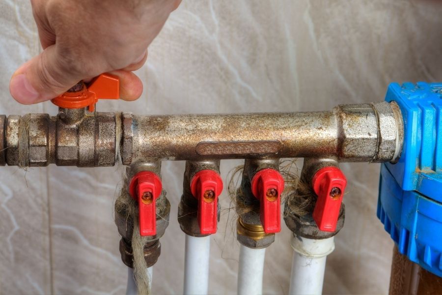 Homeowner turning off water main valve to stop water damage