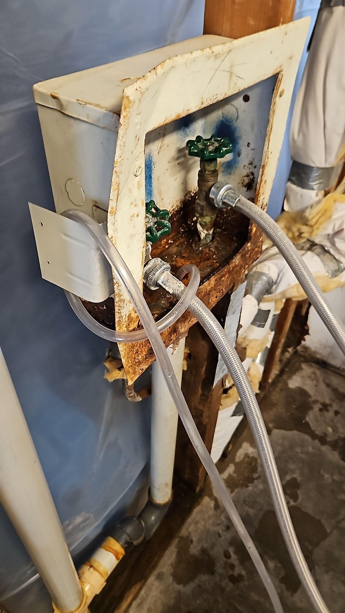 Exposed wall framing after drywall and baseboard removal in sitting room