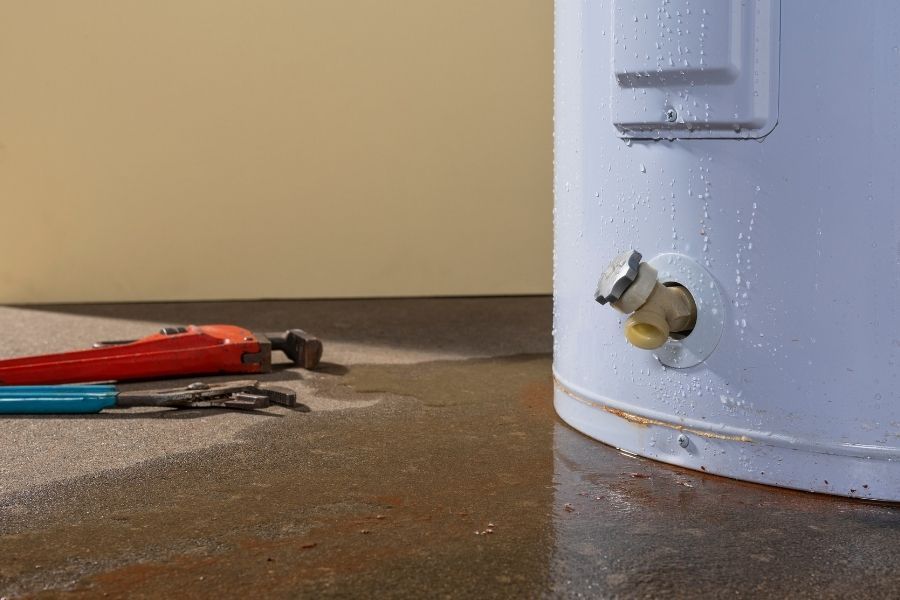 Water heater leak causing water damage on a utility room floor