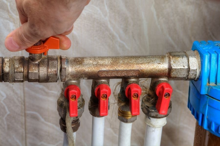 Homeowner turning off main water shut off valve to stop water damage