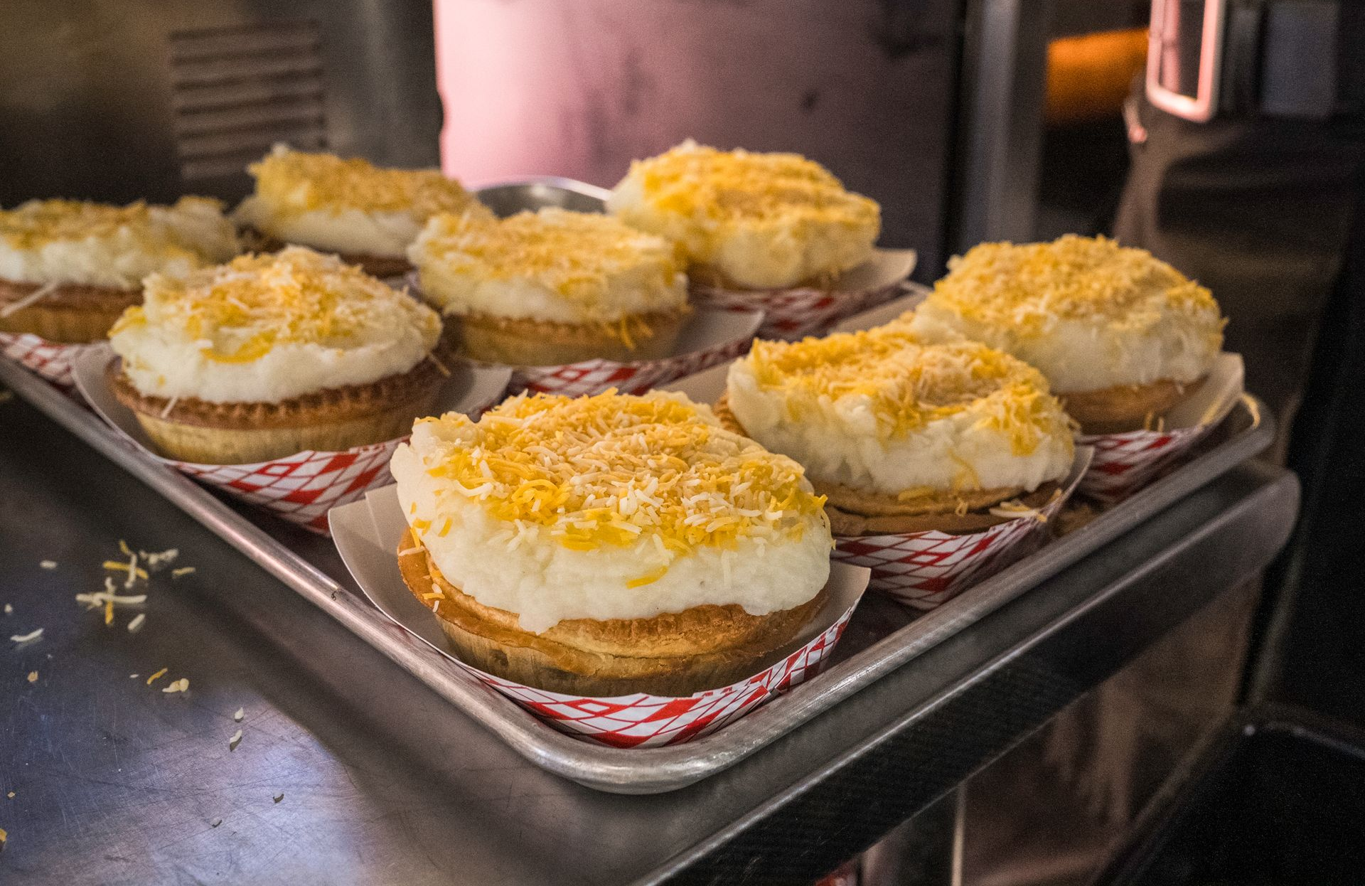 Tray of frosted cupcakes topped with shredded coconut on a baking rack