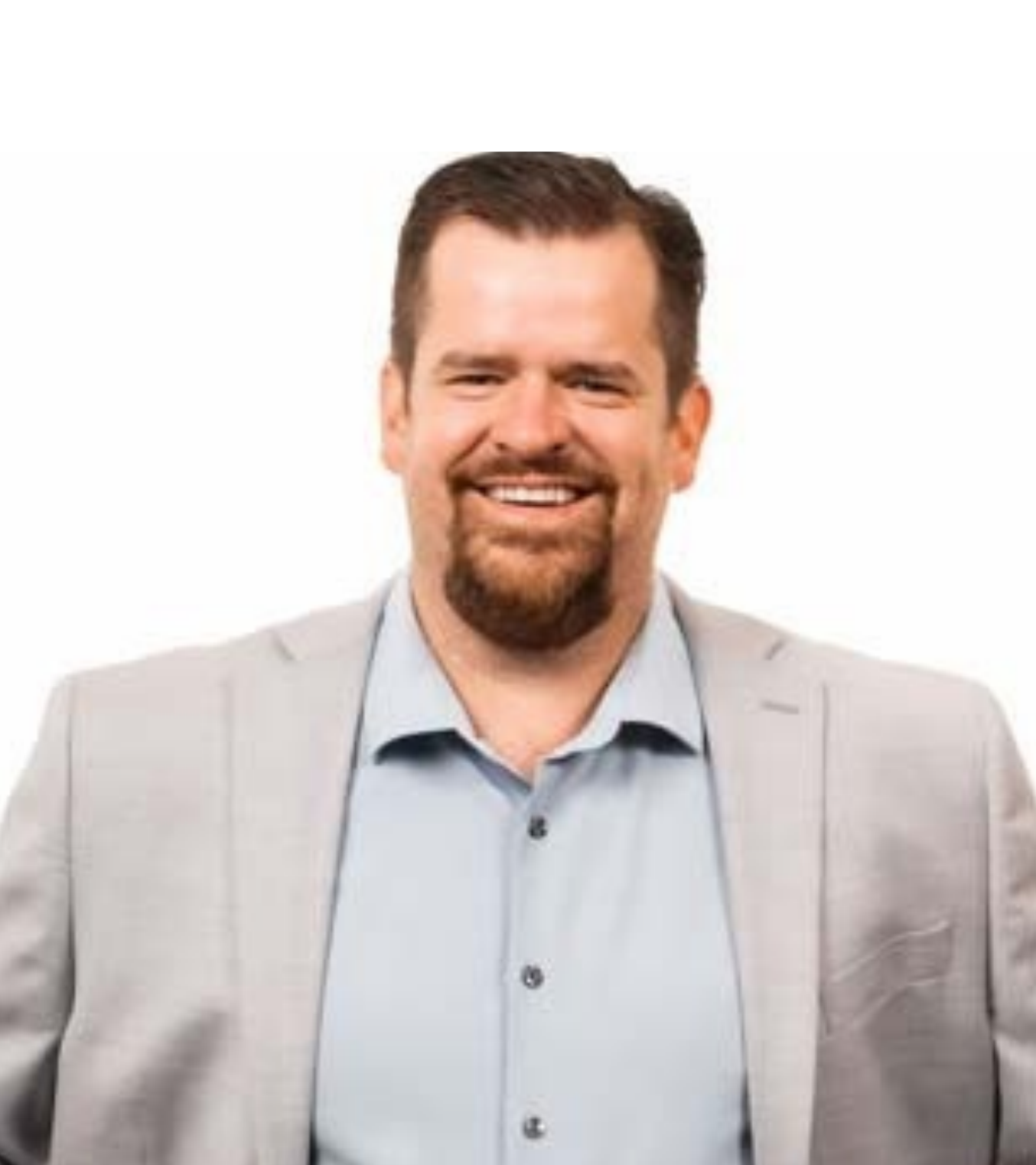 Smiling man in a light gray blazer and blue shirt on a white background