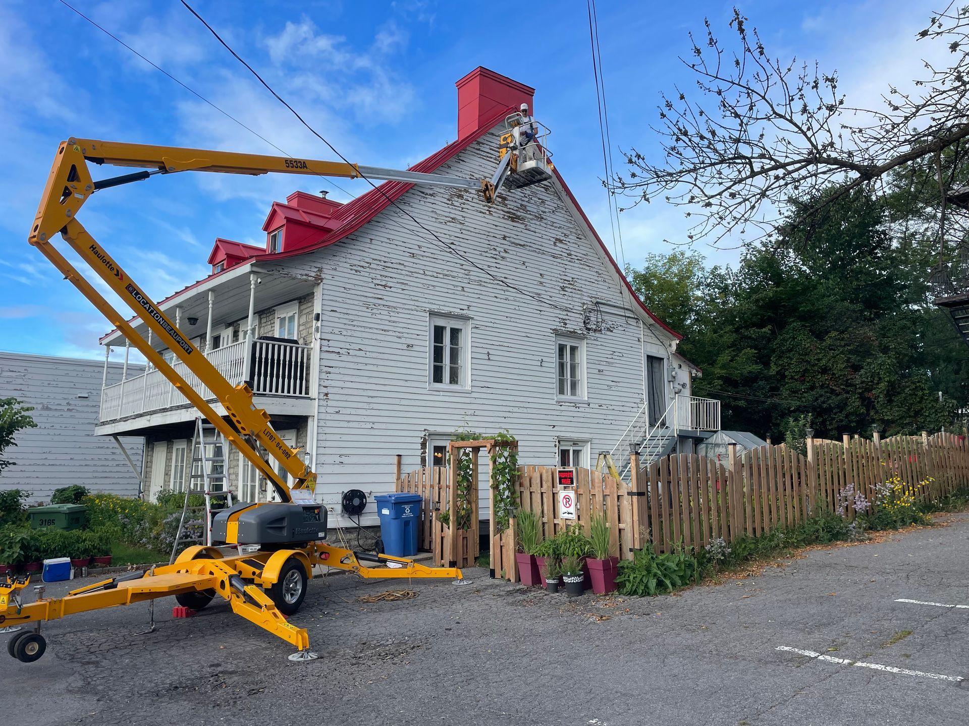 Un ascenseur jaune est garé devant une maison.