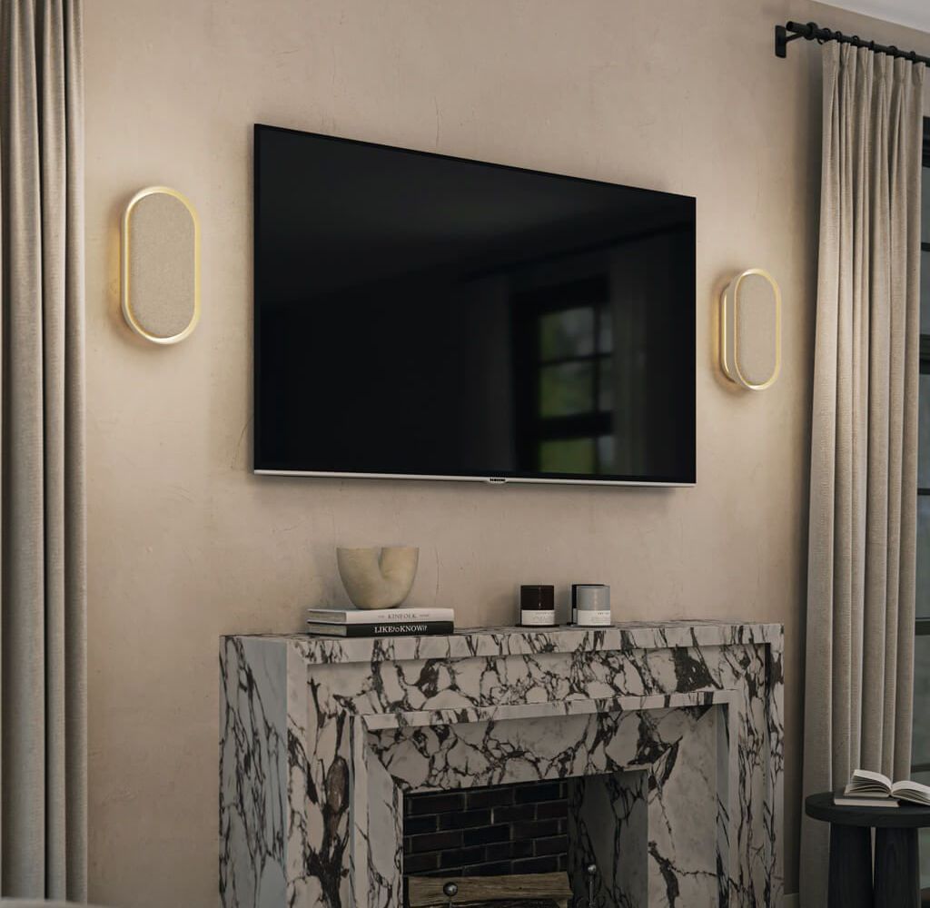 TV mounted above a marble fireplace with sconces, books, and candles in a living room.