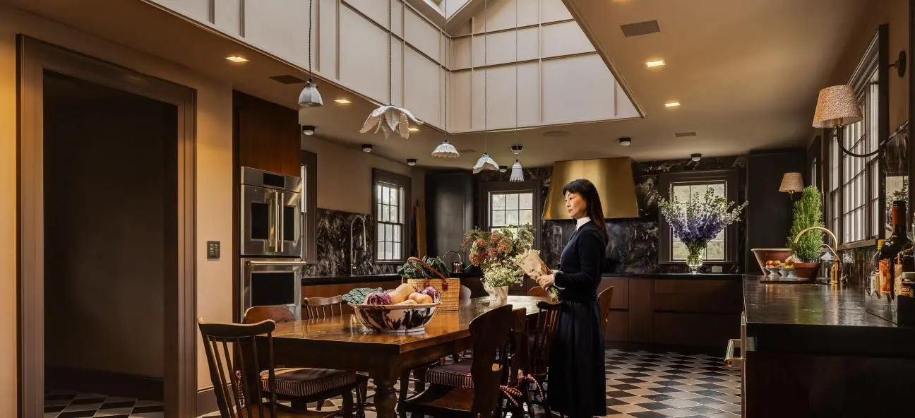 Luxury modern kitchen with dark wood cabinetry, skylight ceiling, pendant lighting, and black-and-wh