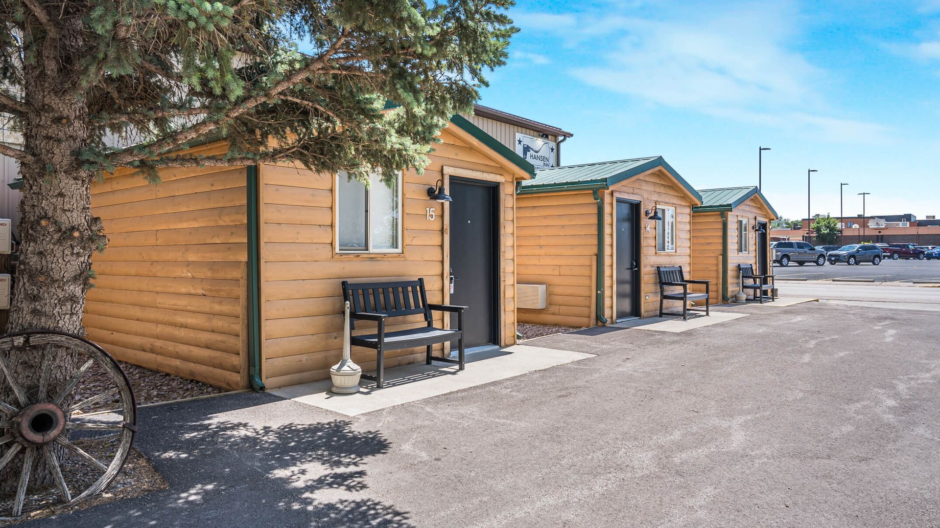 Row of small wooden cabins along a paved path under a clear sky