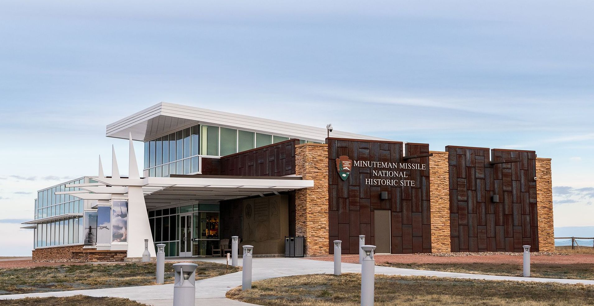 A large building with a lot of windows and a walkway in front of it.