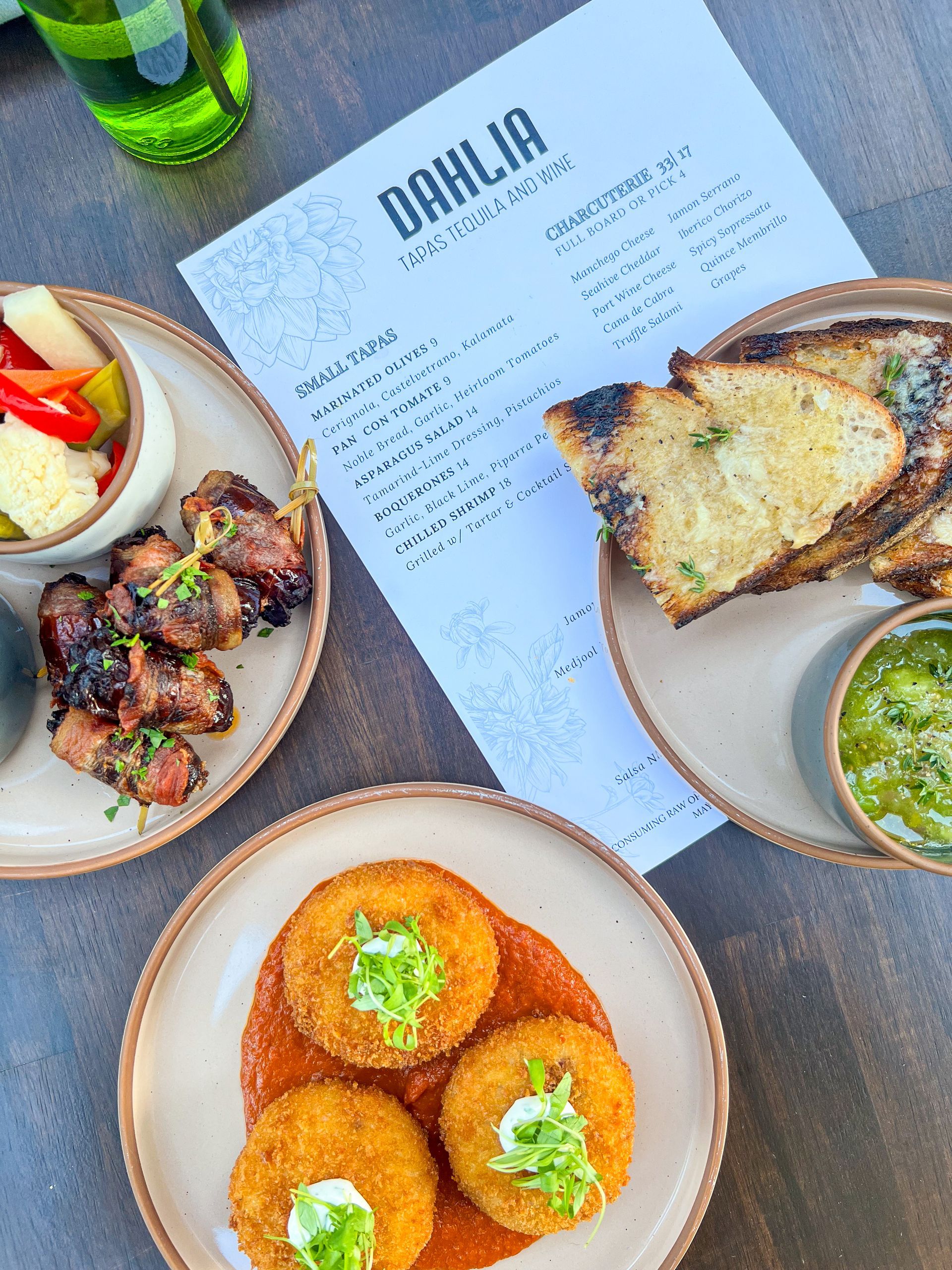 Overhead view of a brunch spread with plated dishes, bread, and a menu on a table