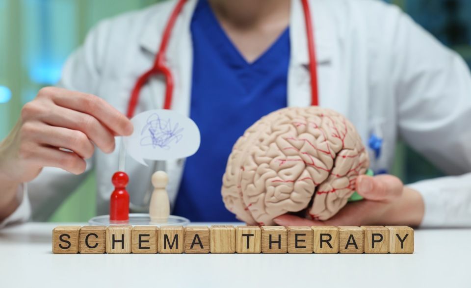 Doctor holding brain model, wooden figures, and