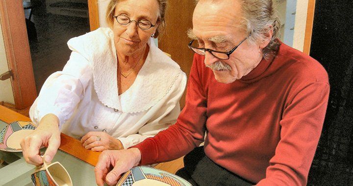 two older people sit at a table