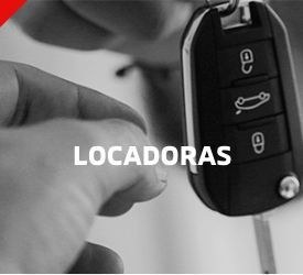 Chave de carro segurada na mão com a inscrição