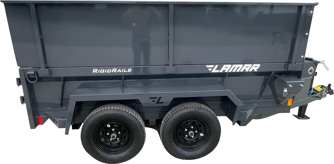 A dark gray Lamar dump trailer with two axles and black tires is parked on a white surface.