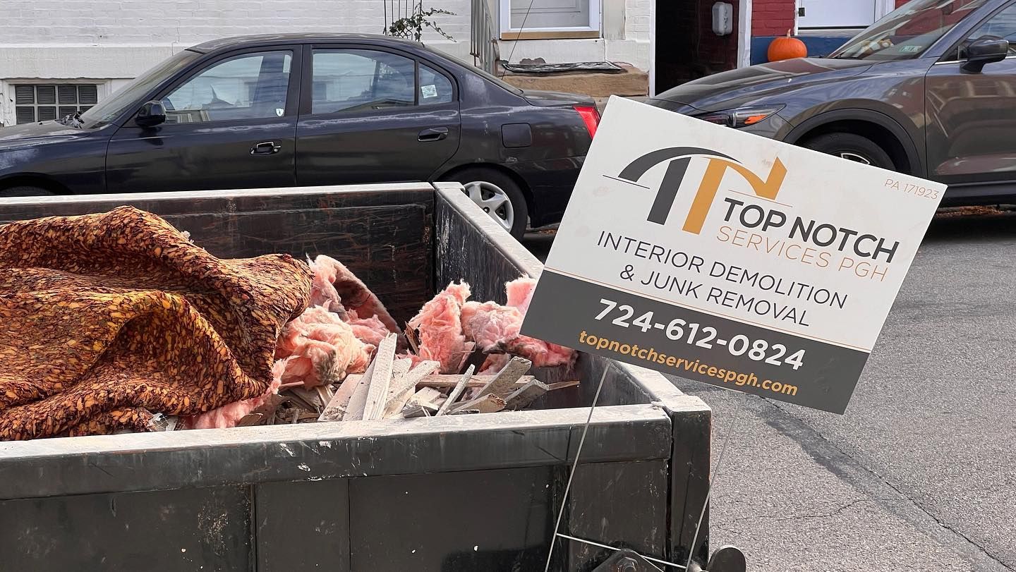 A black dumpster filled with debris with a 