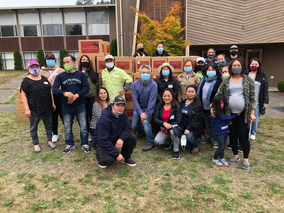 A group of people wearing face masks are posing for a picture in front of a building.