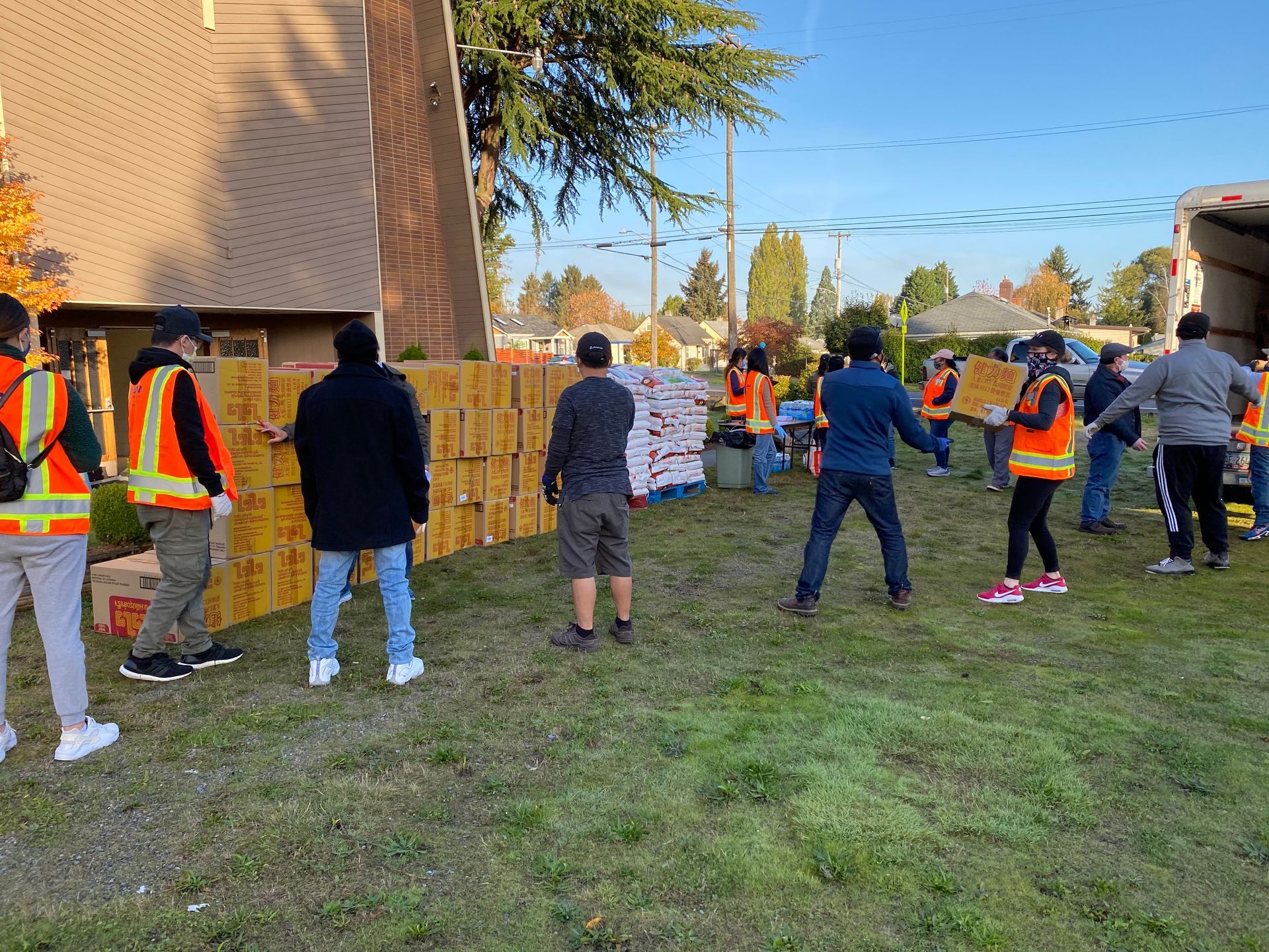 A group of people are standing in a field holding boxes.